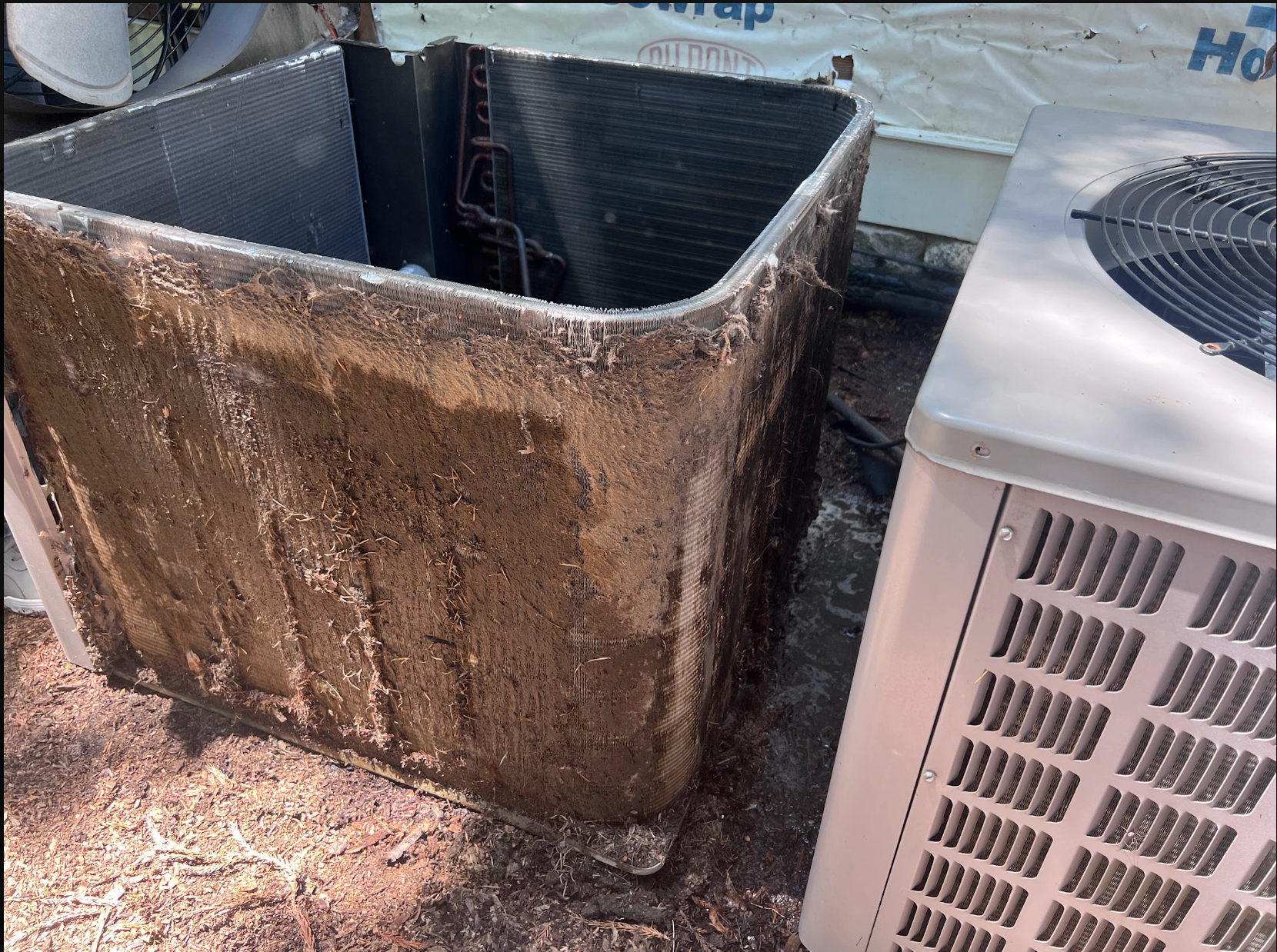 Outdoor AC condenser coil clogged with dirt and debris